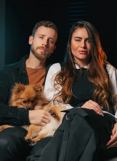 Bruno e Ellen, da MidTrack, sentados no sofá com o cachorro